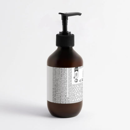 Brown bottle with black pump and white label on a light gray background