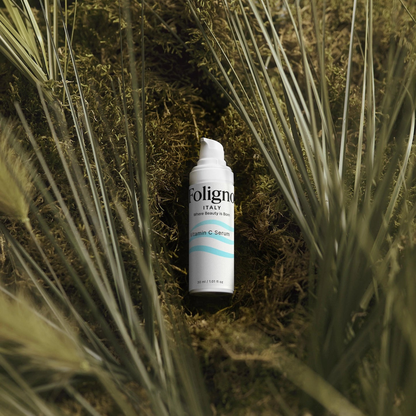 Foligno hair product bottle on a grassy background