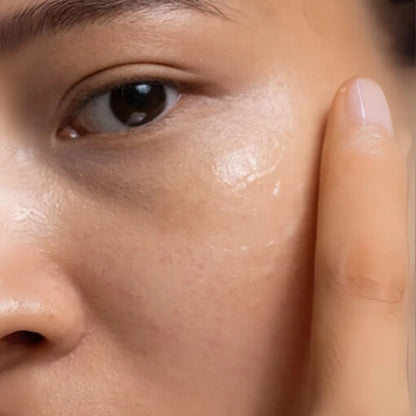 Close-up of a person's eye with a finger touching the skin around the eye area.